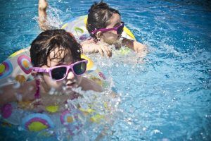Dos niñas bañandose en una piscina.