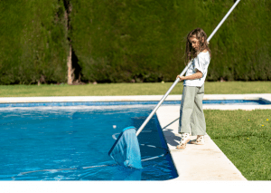 Niña limpiando piscina